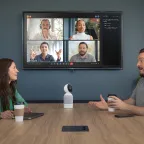 Vibe Bot on conference table connecting in-room team to remote video call participants with AI-powered live notes on screen