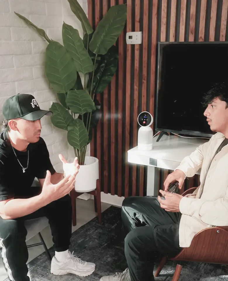 Two men having a discussion in a room with a Vibe Bot on the table.