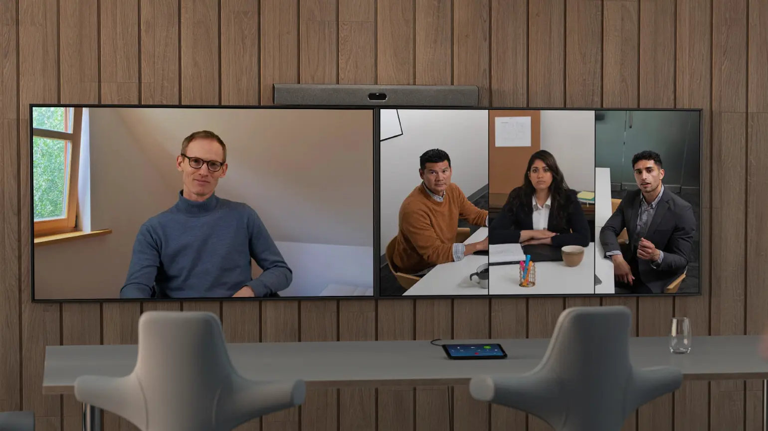 Neat Bar Pro Microsoft Teams video bar displaying hybrid meeting with remote and in-room participants