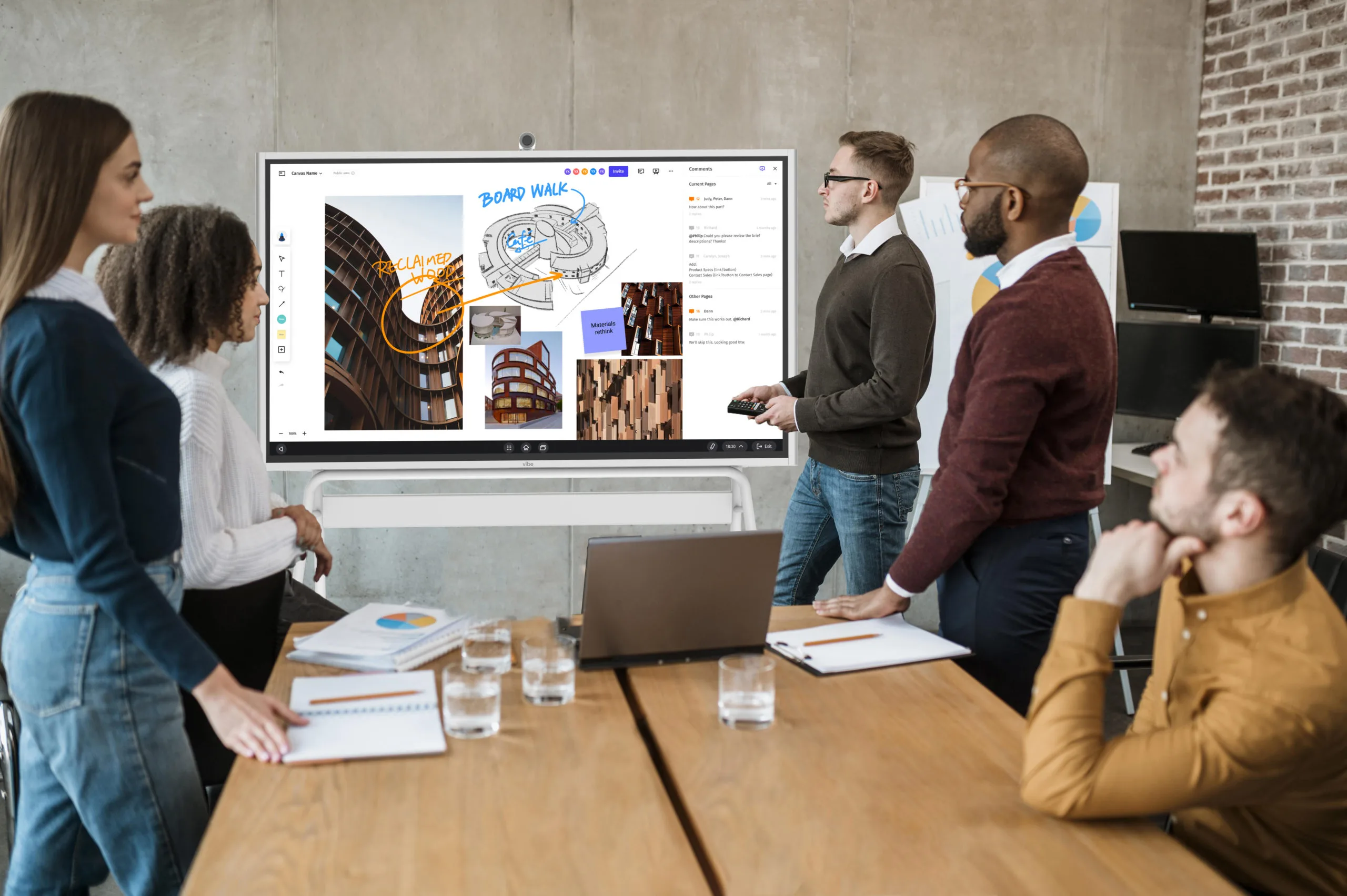 Vibe Board displayed in a conference room with a team collaborating on architectural drawings and project visuals during a meeting
