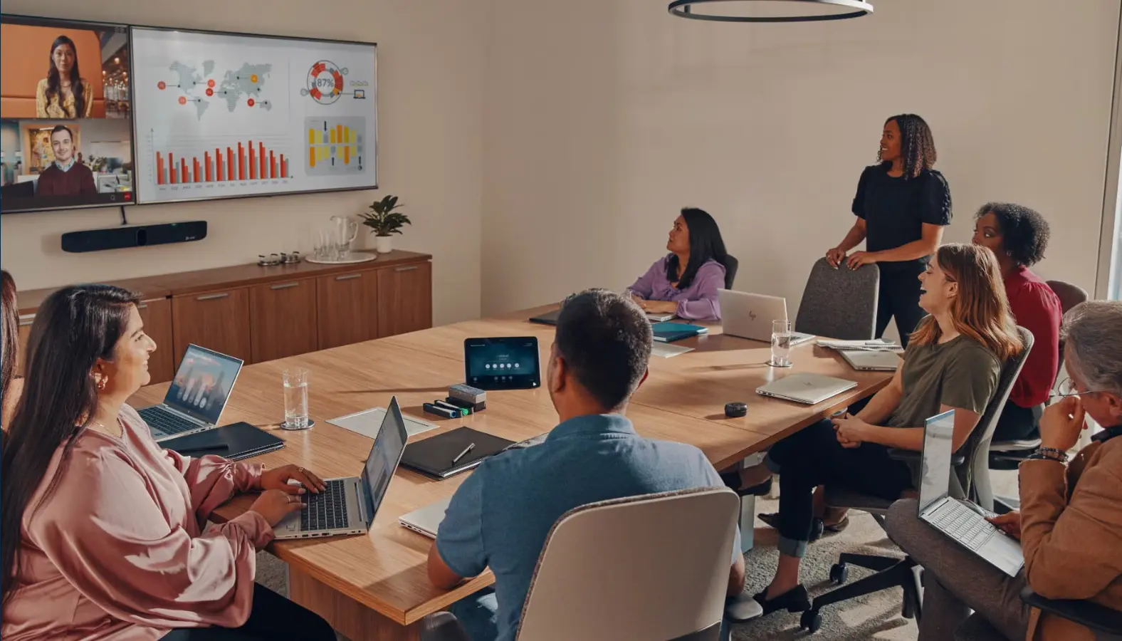 Poly Studio X70 dual-camera video bar in large boardroom with hybrid meeting on display