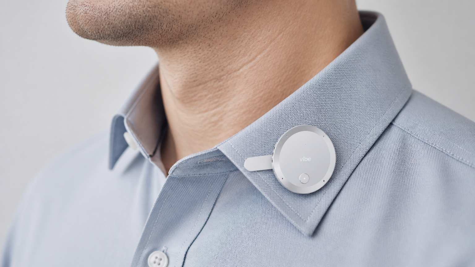Vibe Dot wearable AI recorder clipped to a shirt collar, showing its compact clip-on form factor.